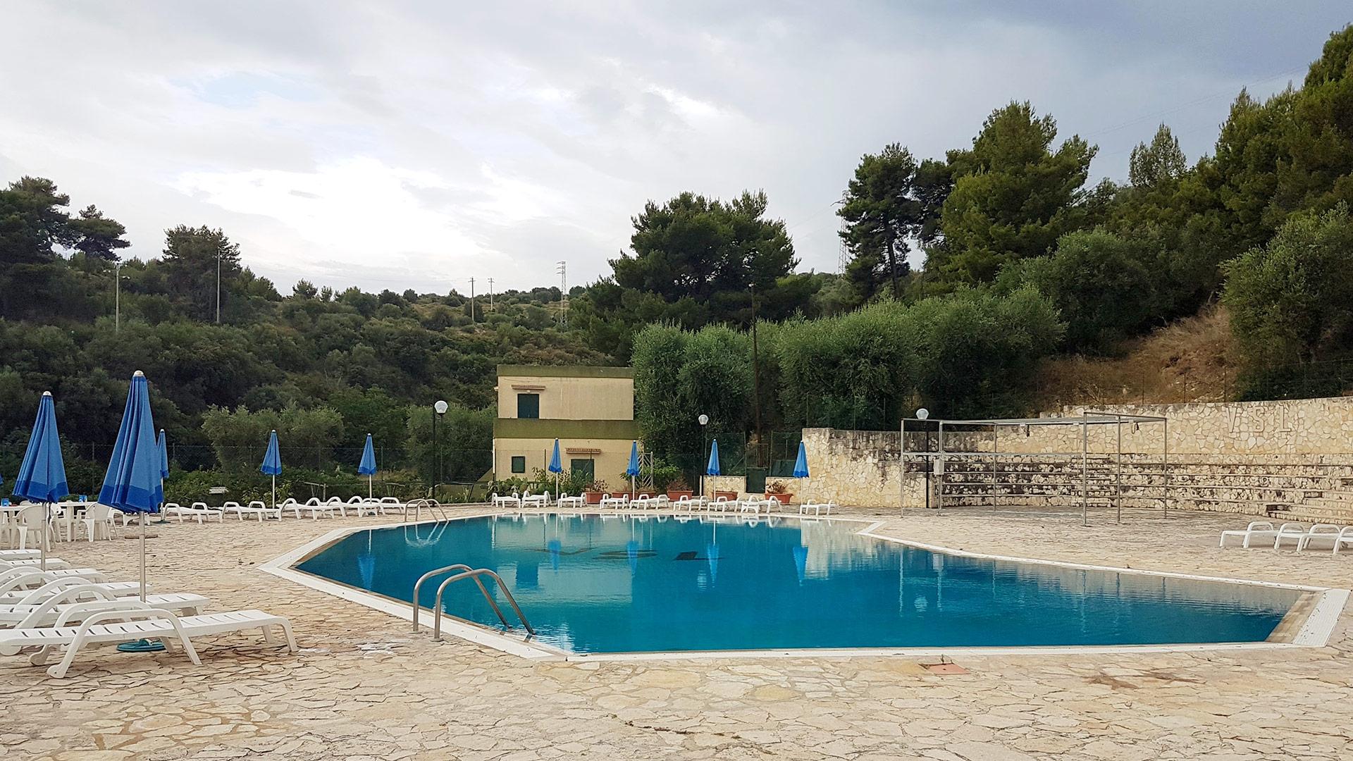 Terrazza con tavolo e sedie in legno, pianta e lanterna decorativa.