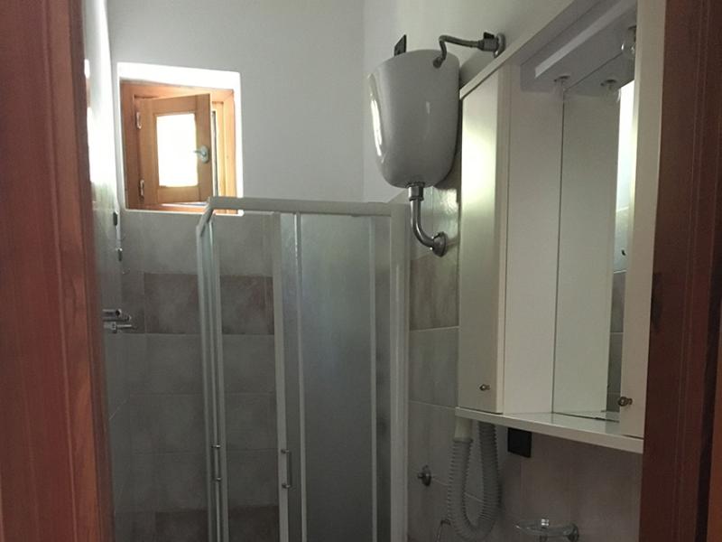 Sala luminosa, tavolo bianco, camino in mattoni, atmosfera accogliente e moderna.