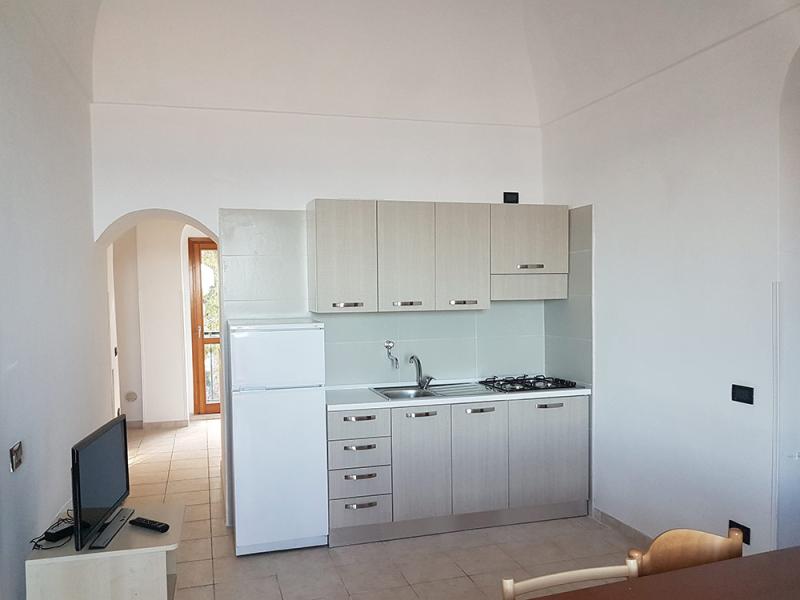 Cucina moderna, luminosa e minimalista con elettrodomestici essenziali, invita alla semplicità.